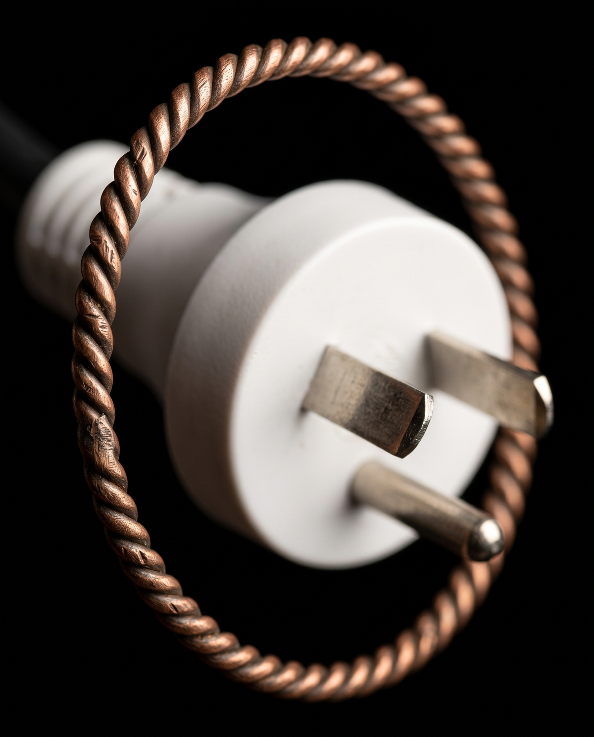 Anillo tensor de cobre trenzado alrededor de la ficha de un cable eléctrico