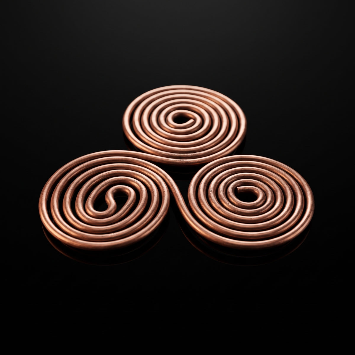 Triskelion de cobre, triple espiral celta, foto macro